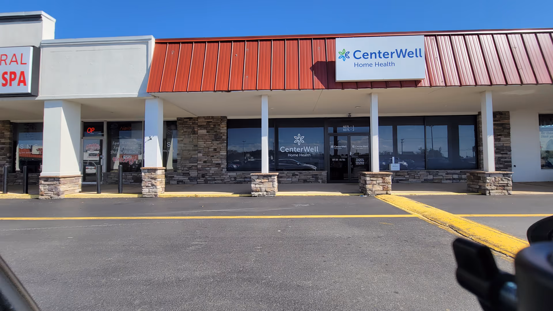 Exterior storefront of CenterWell Home Health in a strip mall with stone accents.