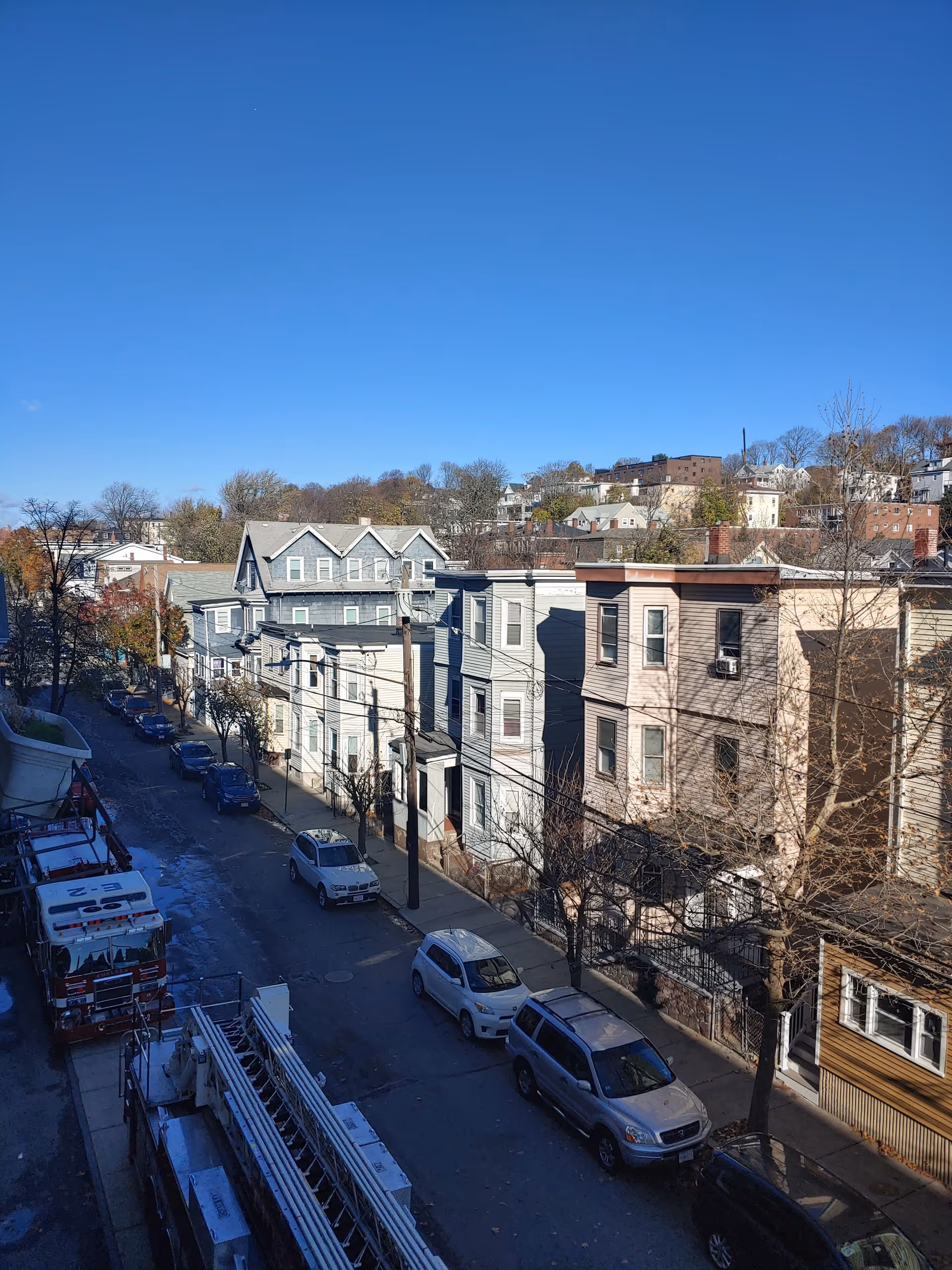 Street view of colorful row houses along a quiet urban avenue