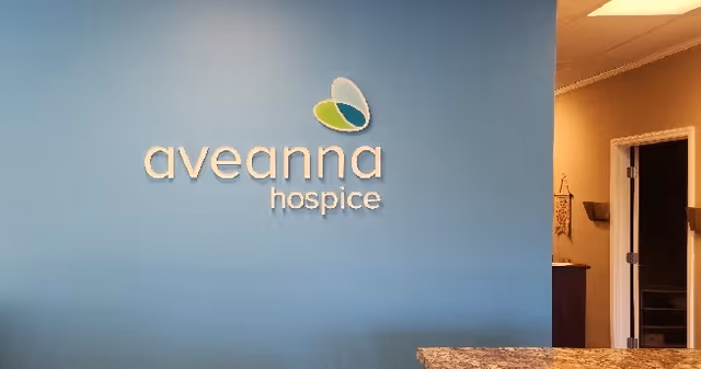 Blue wall with Aveanna Hospice sign and doorway in reception area