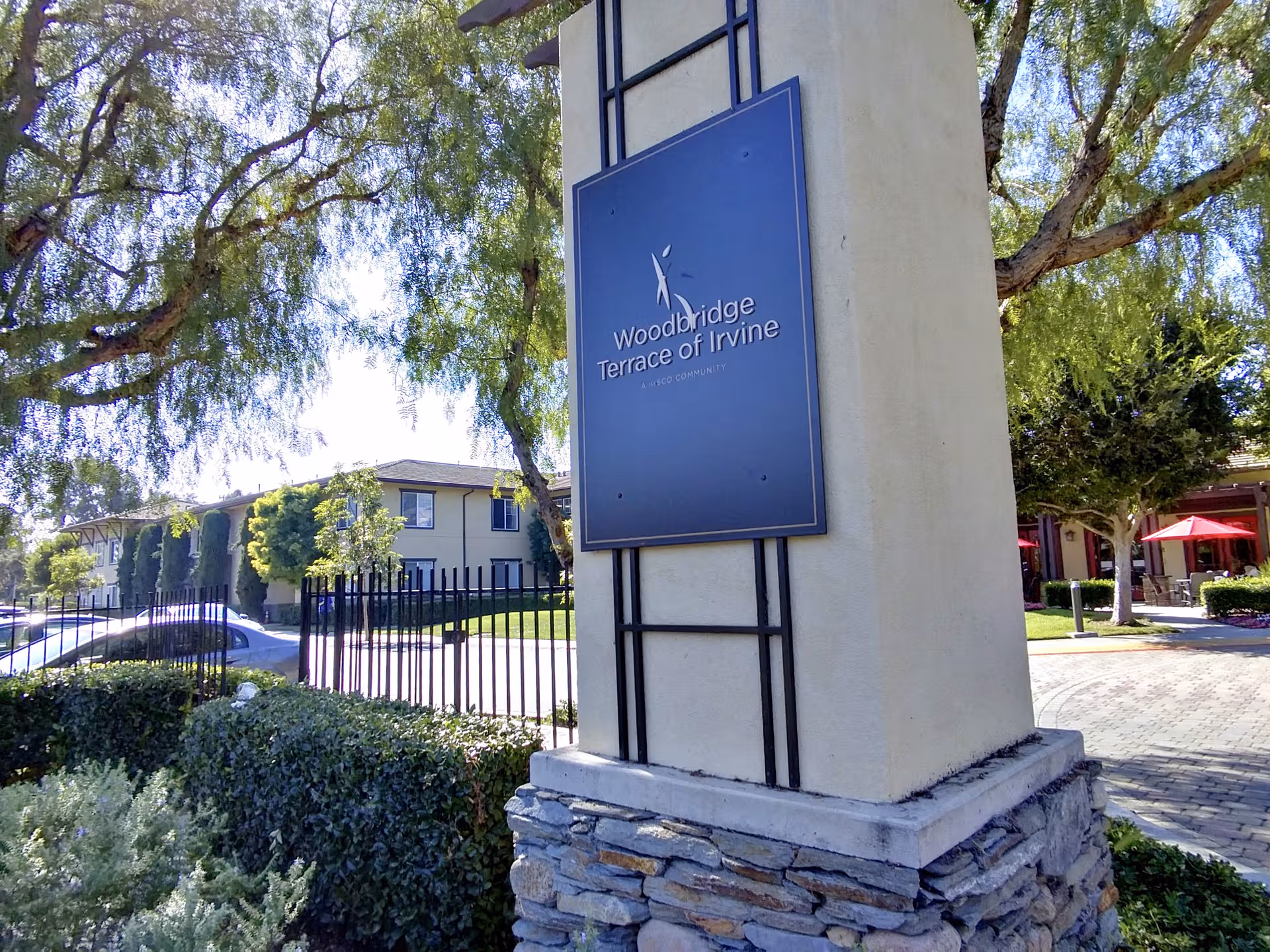 Exterior view of Woodbridge Terrace sign on a stone pillar near the entrance.