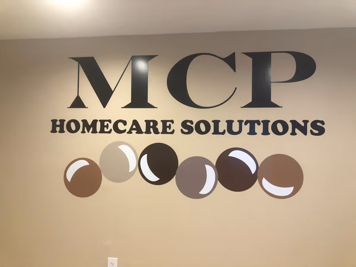 Interior wall with MCP Homecare Solutions logo and circular decorative shapes.