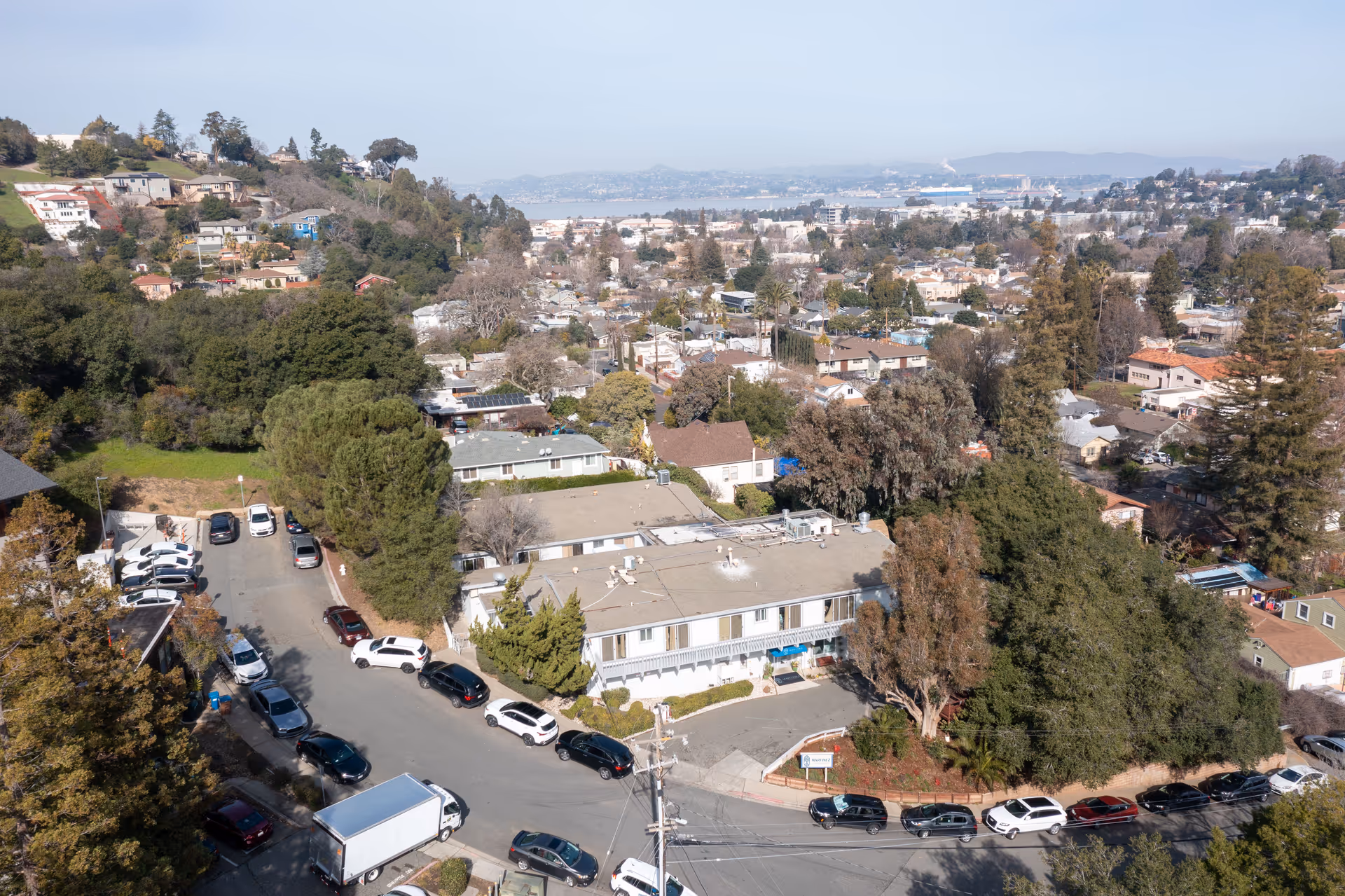 Aerial view of a senior living facility area with a parking lot and surrounding neighborhood.