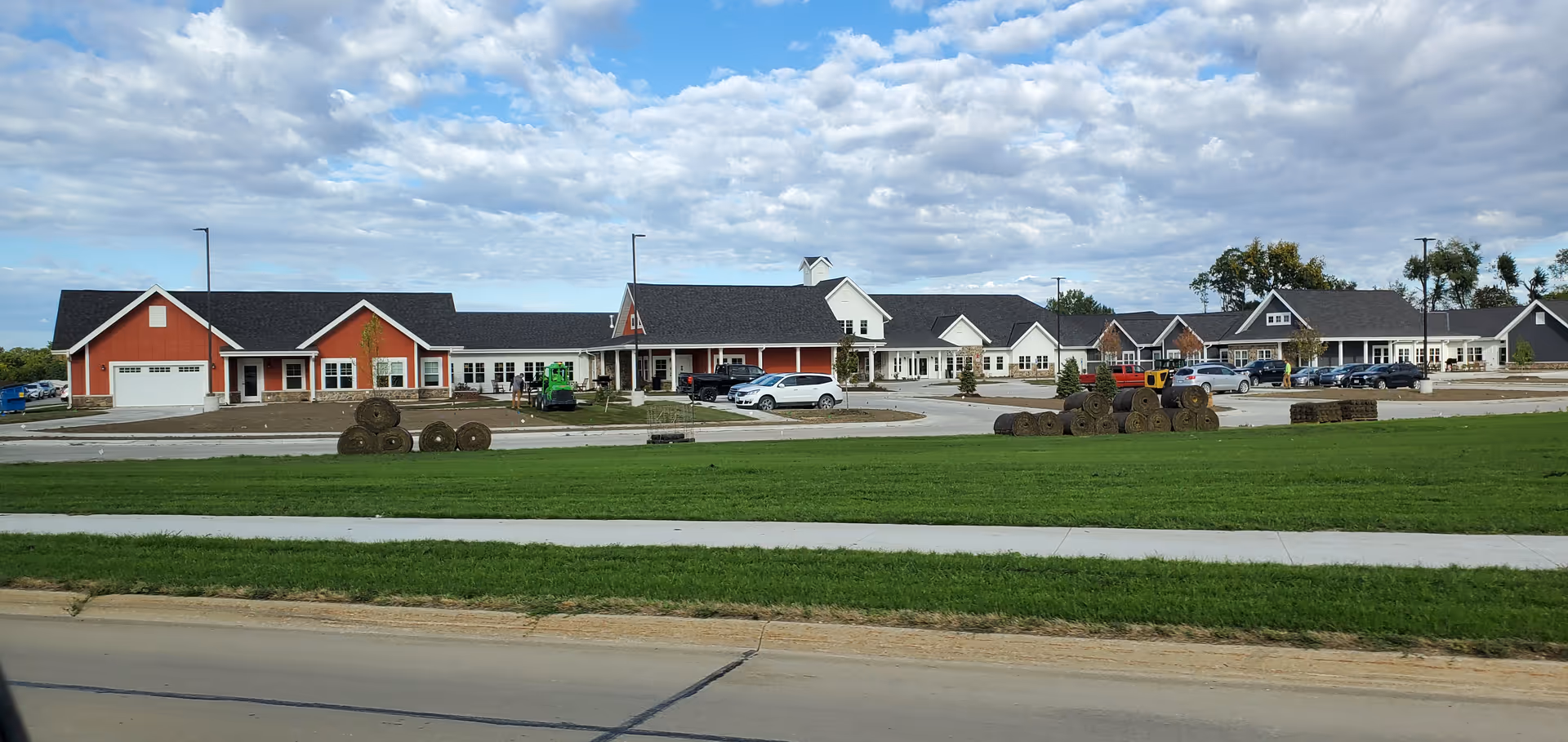 Exterior view of Westwing Place, a WellSpire Community, showing connected buildings, parking, and lawn.