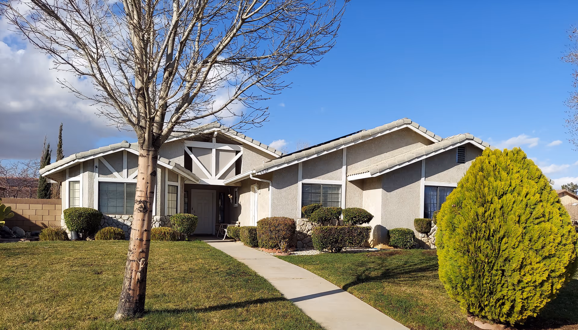 Front view of a single-story facility with a manicured lawn and shrubs.