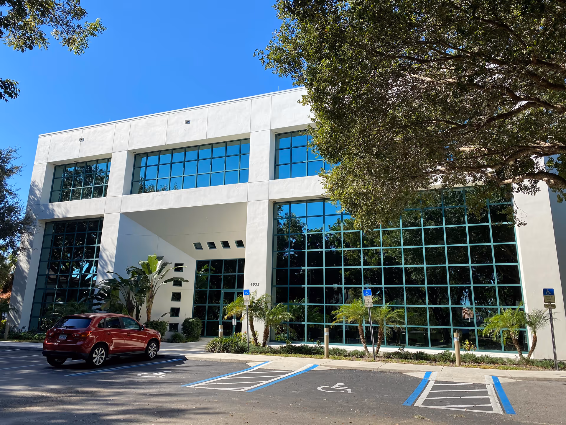 Exterior view of a Dial-A-Nurse facility with a glass facade and parked cars.