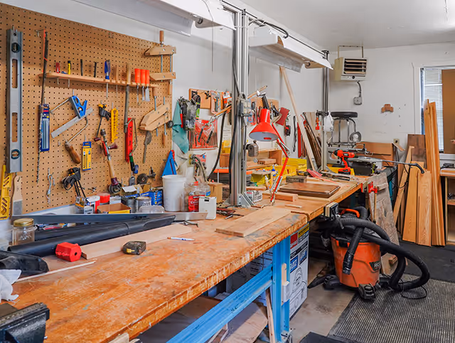 A well-equipped woodworking shop with organized tools and a large workbench.