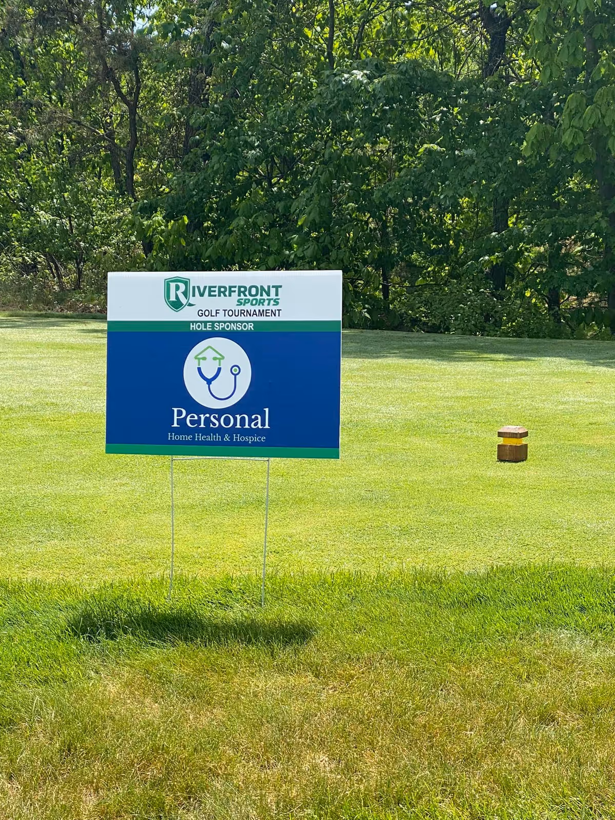 Outdoor grassy area with sponsor sign for Personal Home Health & Hospice.