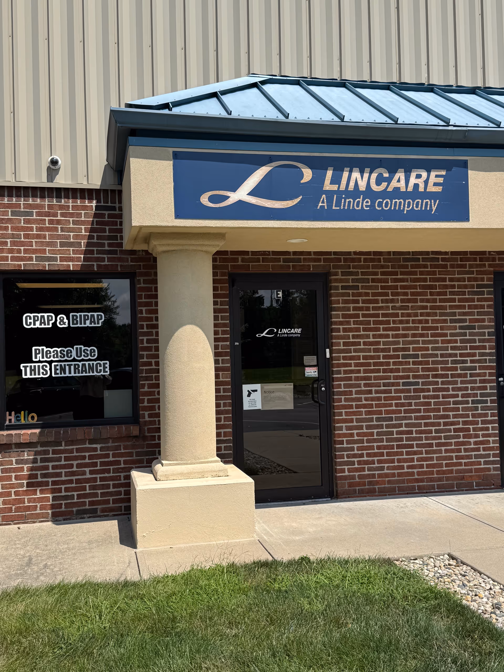 Exterior view of a LINCARE facility entrance with brick facade and sign.