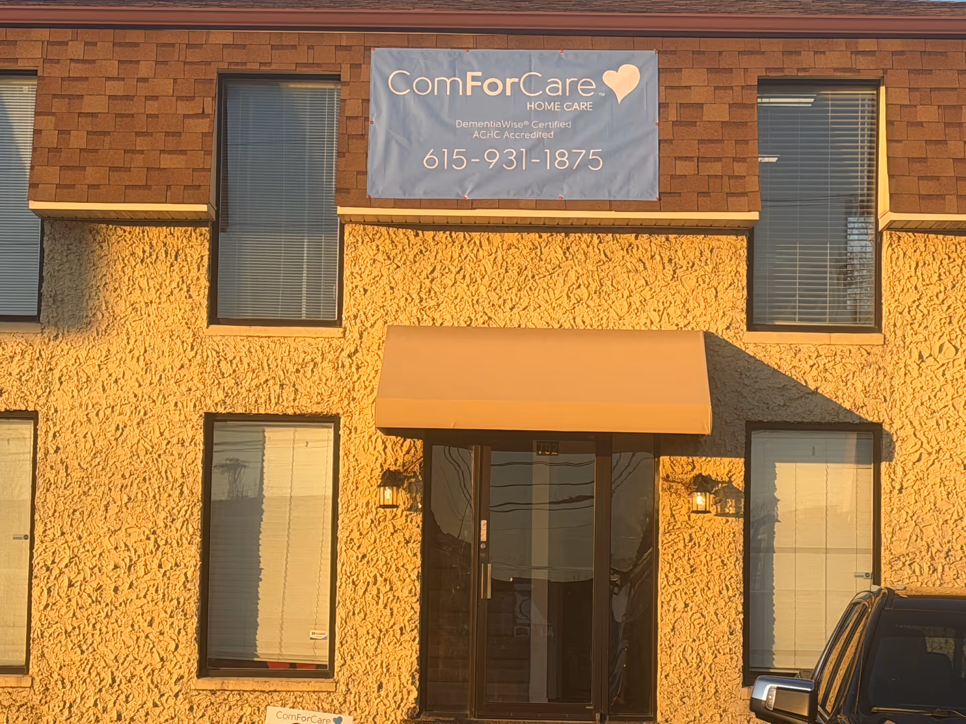 Exterior of a brick building with a ComForCare banner above the entrance.