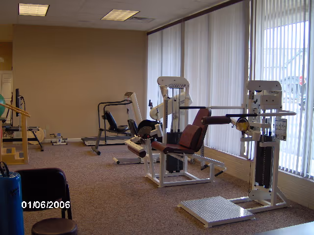 Rehab gym with weight machines and cardio equipment in a bright interior.