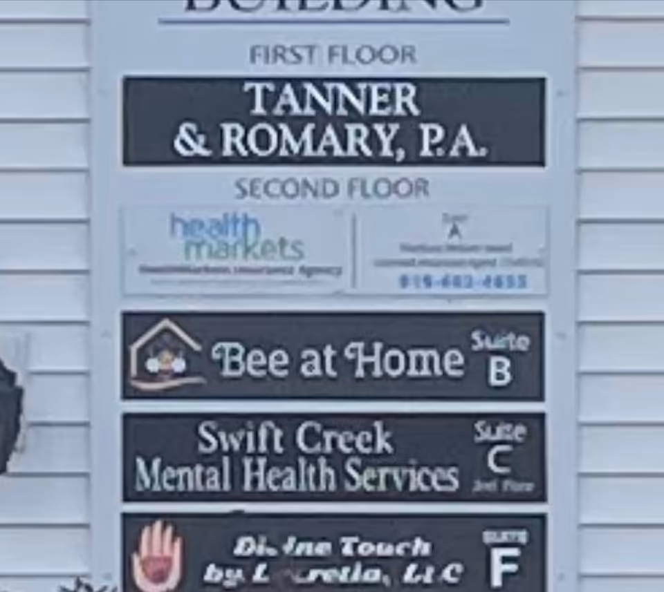 Exterior building signboard listing tenants, including Bee at Home and Swift Creek Mental Health.