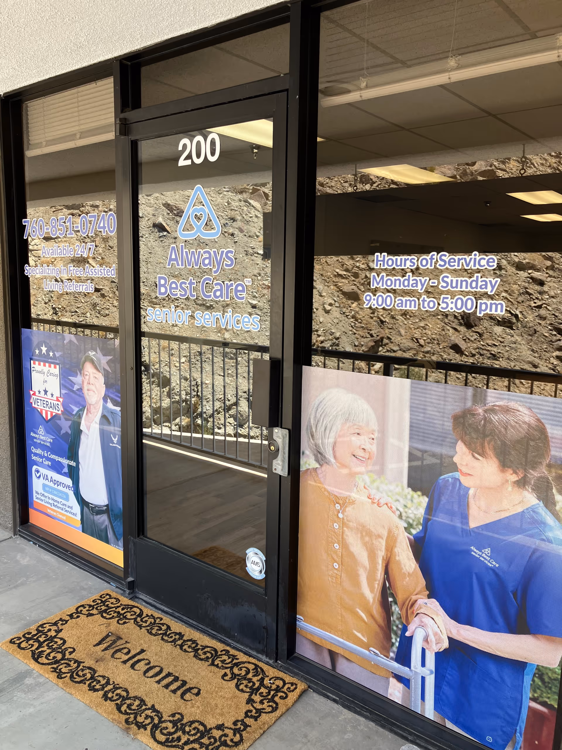 Glass storefront entrance with Always Best Care signage and service posters outside.
