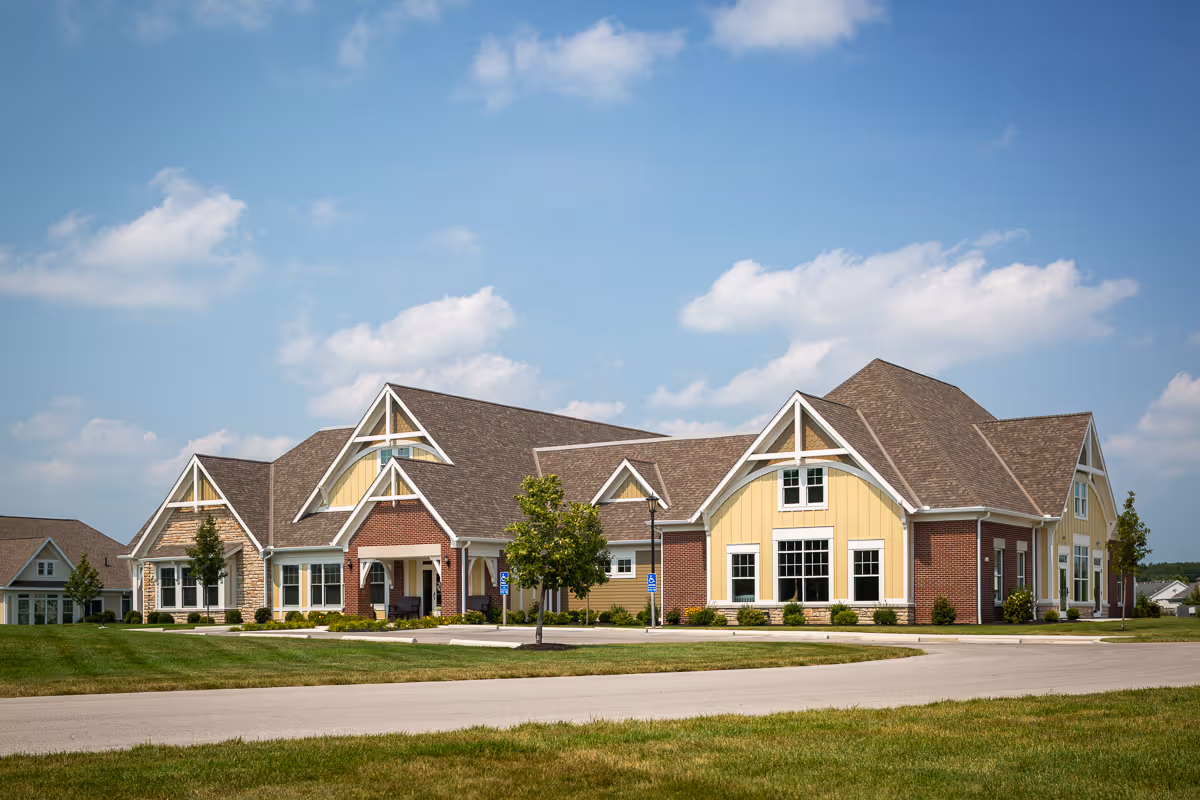 Exterior view of Otterbein Sunset Village SeniorLife Community building with brick, tan siding, and gabled roofs.