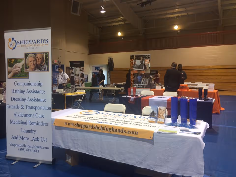 Indoor expo with booths and banners promoting Sheppard's Helping Hands in a gym.