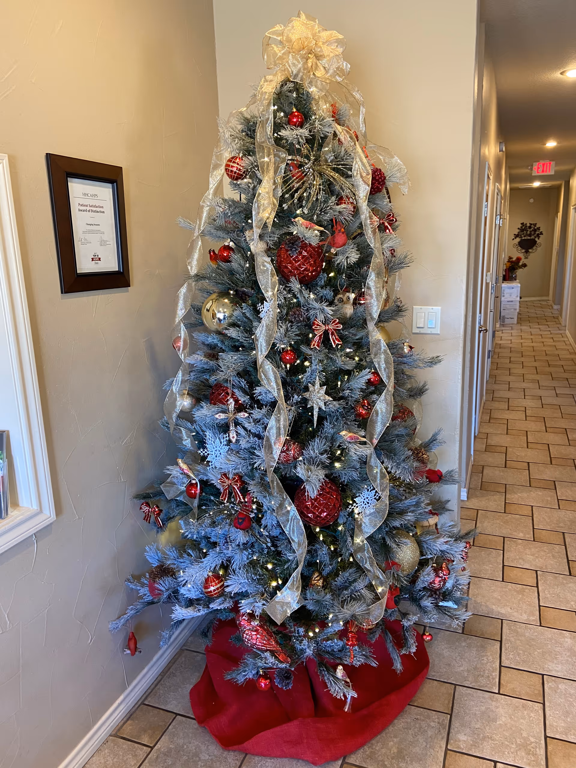 Decorated Christmas tree in a hallway of a senior living facility.