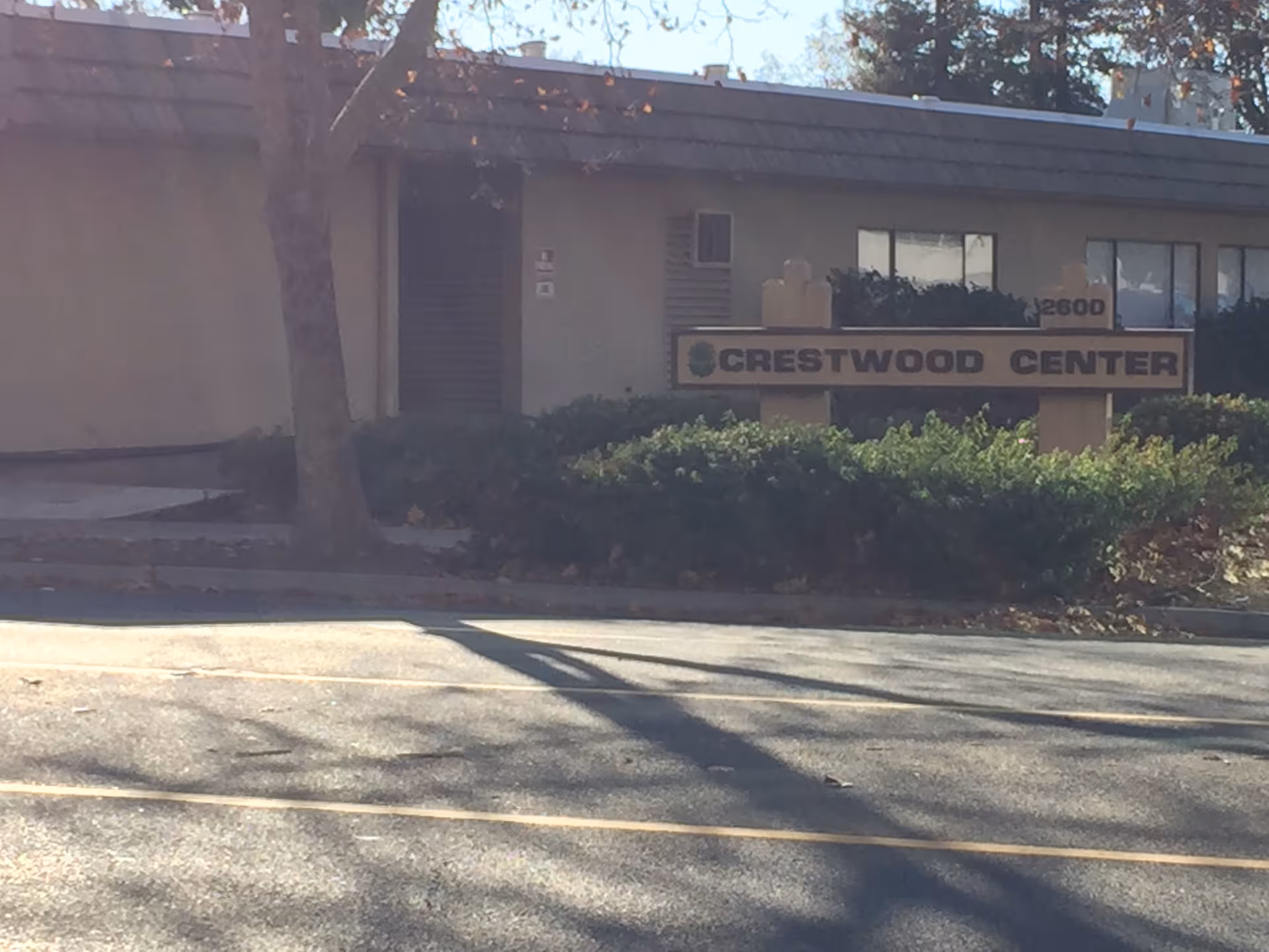 Exterior of Crestwood Center building with sign, shrubs, and trees.