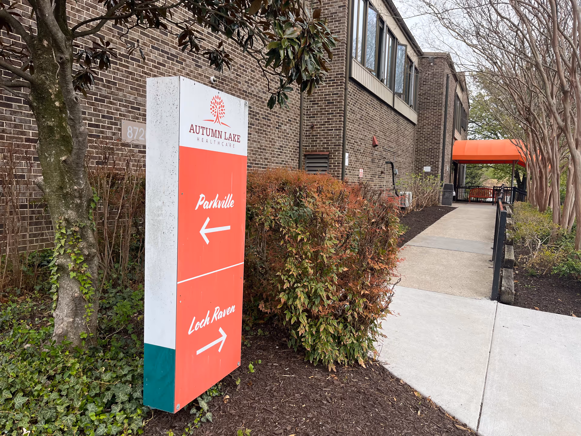 Exterior view of Autumn Lake Healthcare at Loch Raven with sign and walkway.