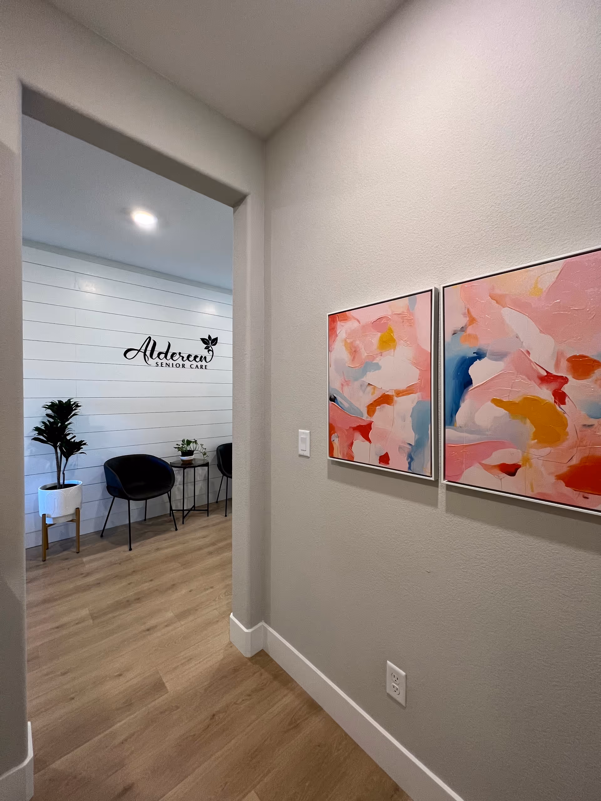 Hallway leads to a reception area with Aldereen Senior Care logo on a white paneled wall.
