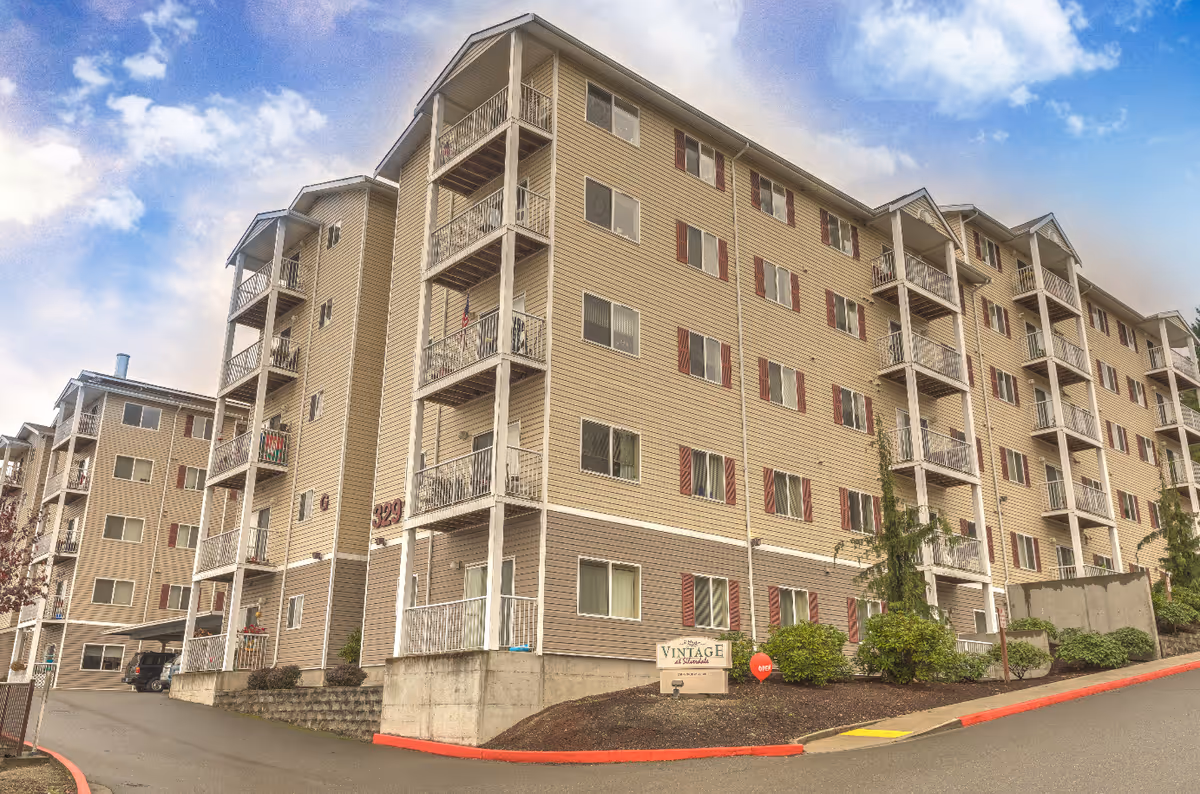 A multi-story beige senior living building with balconies and a Vintage at Silverdale sign.