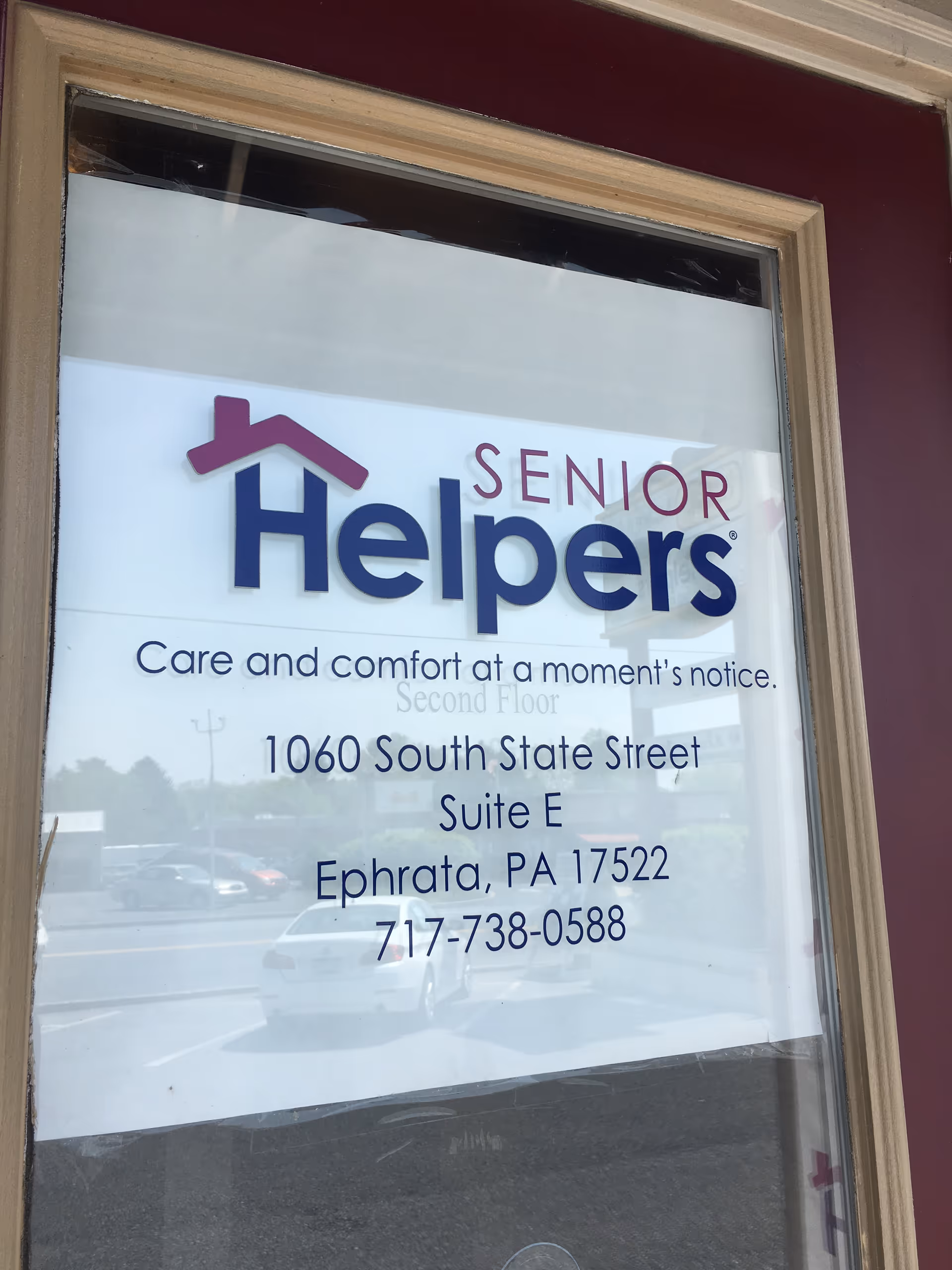 Window display with Senior Helpers logo and address for a Lancaster County facility.