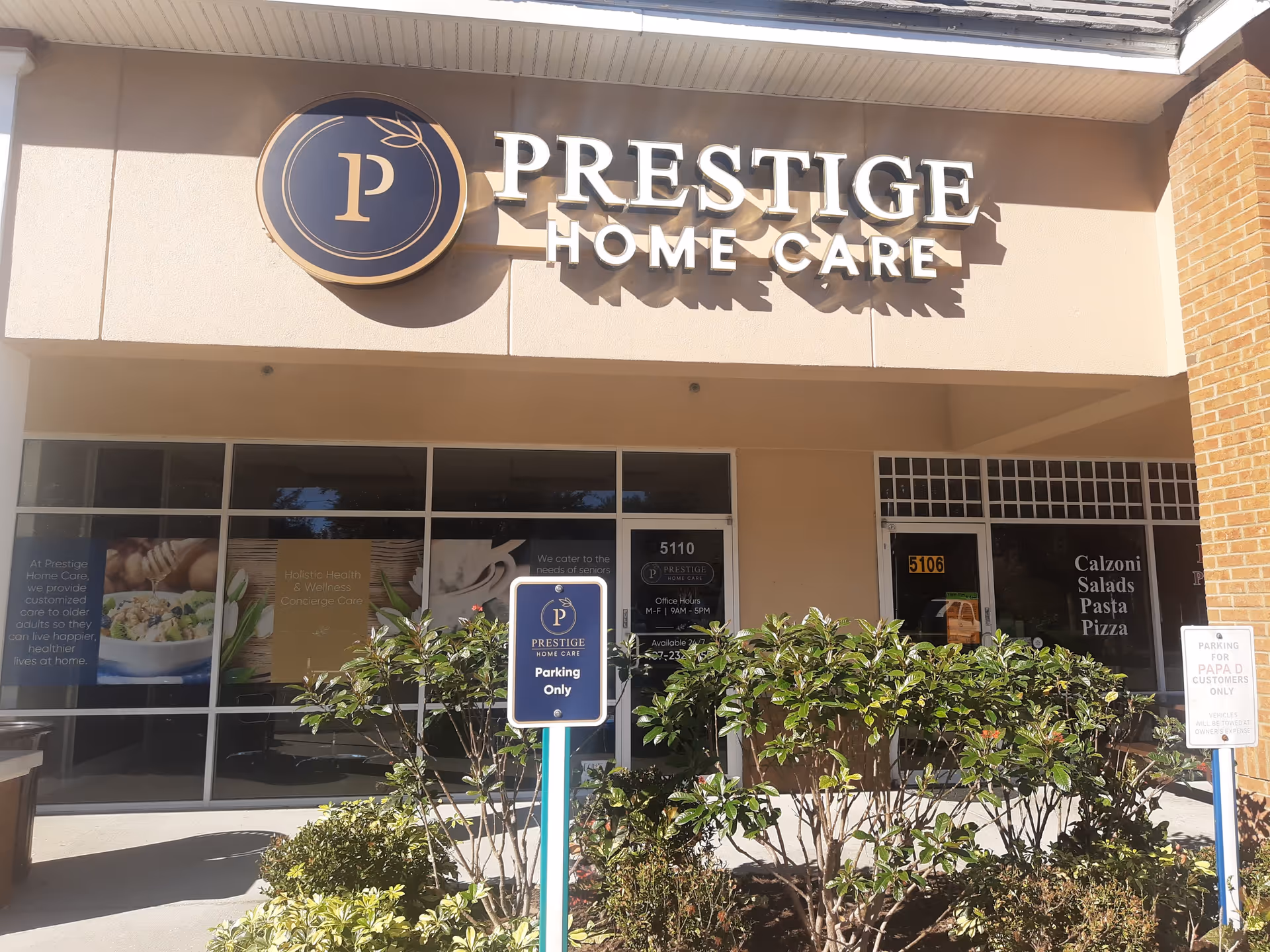 Storefront of Prestige Home Care Orlando with large sign, glass doors, and landscaping.