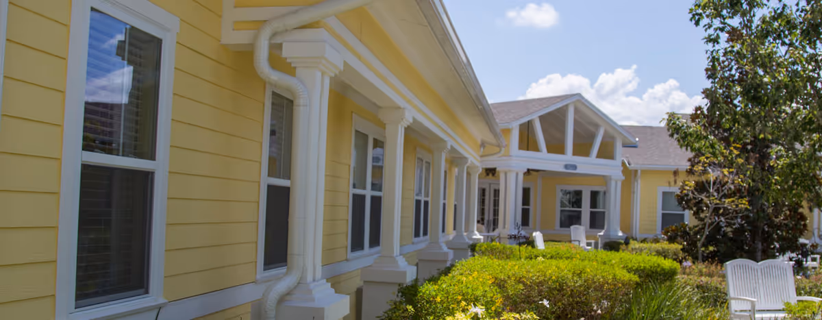 Yellow Serenades at Longwood exterior with white trim and shrubs.
