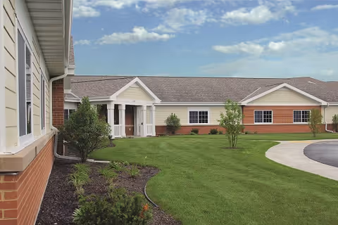 Exterior view of The Gardens at Ridgestone, a single-story brick facility with manicured lawn.