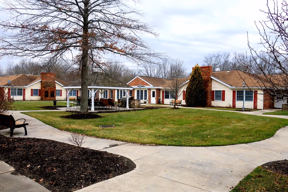 A courtyard at Kensington At Anna Maria featuring paths, benches, and residential buildings.