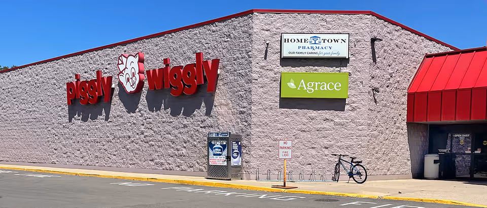 Exterior view of a brick building with large Piggly Wiggly sign and Agrace signage in Dodgeville.