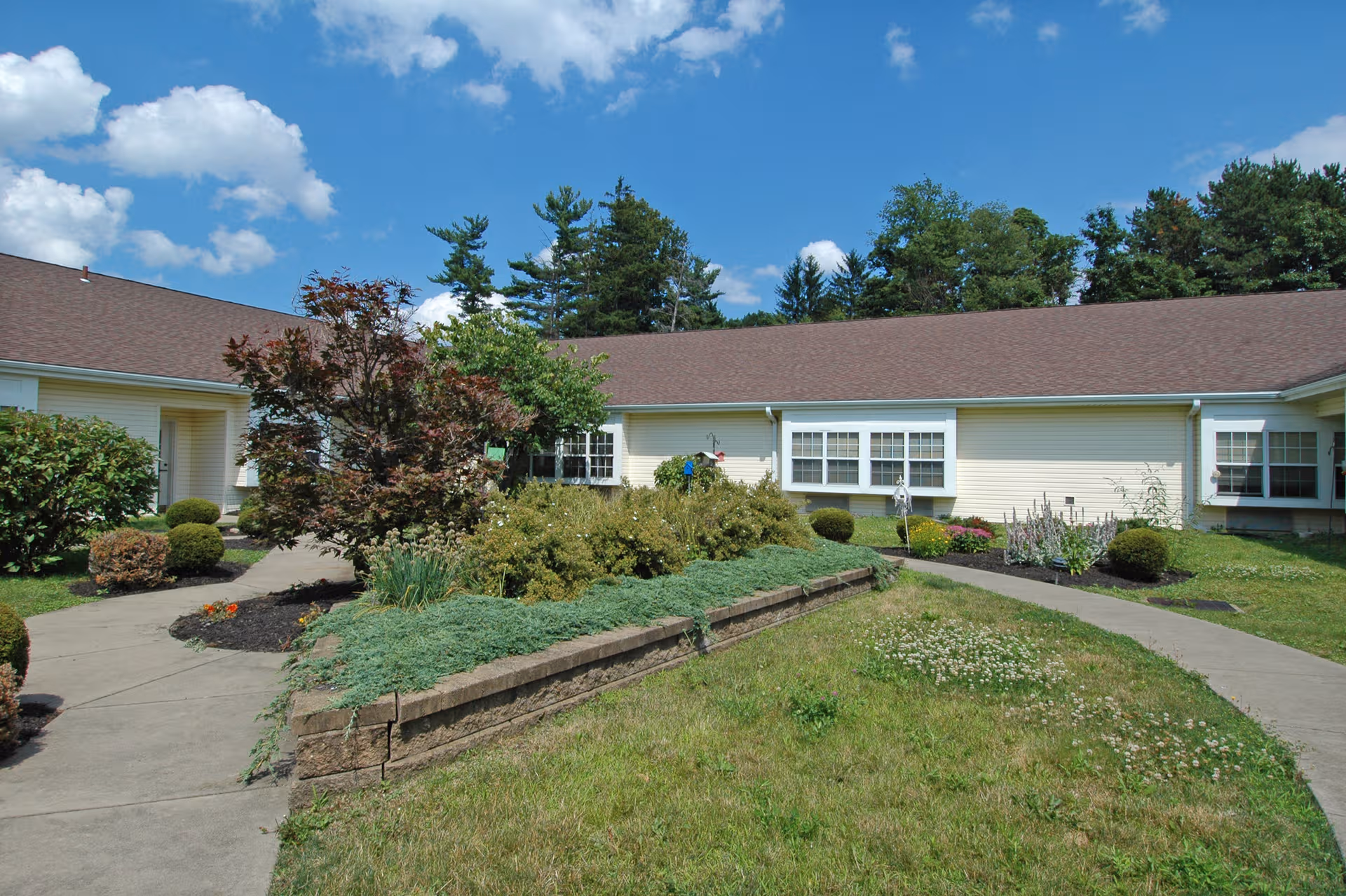 Celebration Villa of Chippewa exterior with walkway and manicured garden beds.