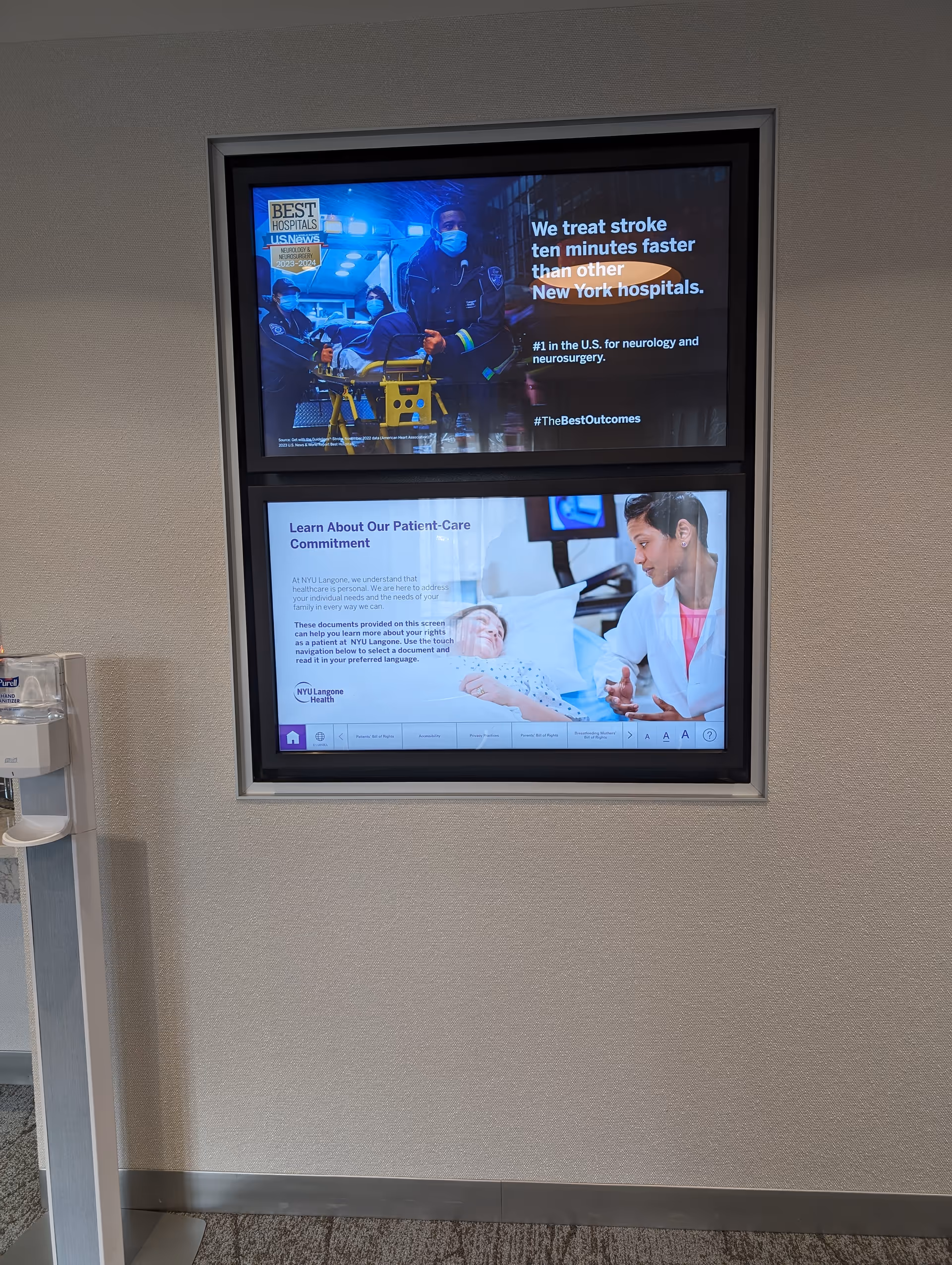 Interior hallway with two wall-mounted display screens and a water cooler.