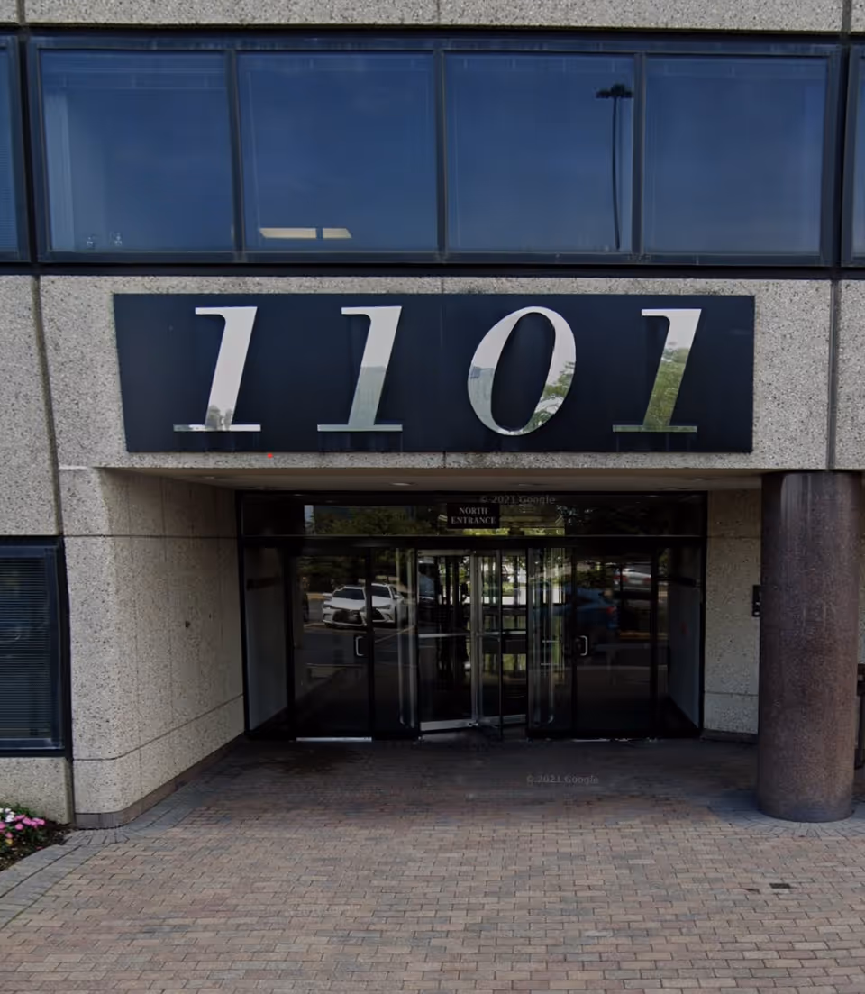 Exterior building entrance with large 1101 sign and glass doors.