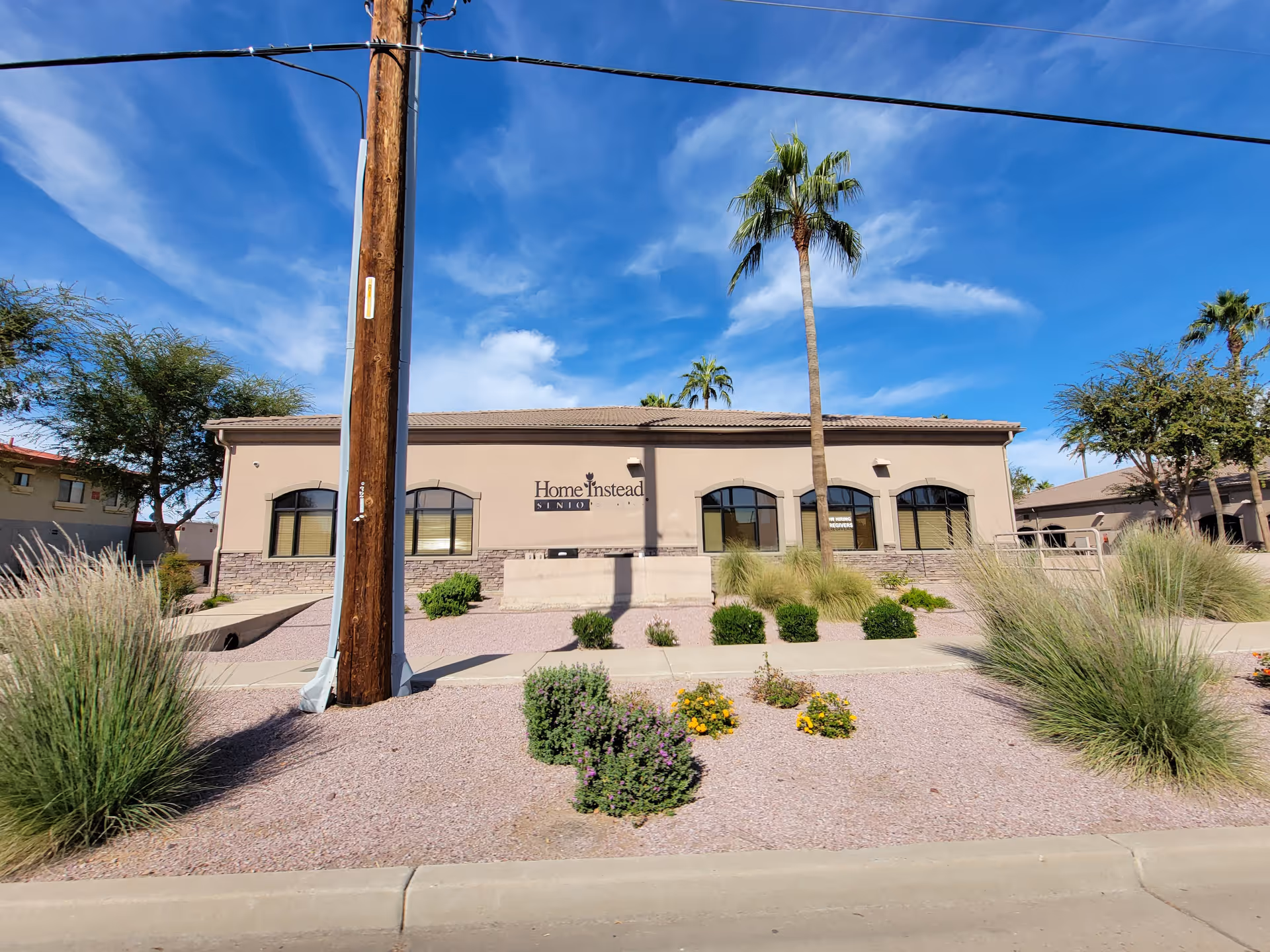 Front view of Home Instead senior care facility with desert landscaping.