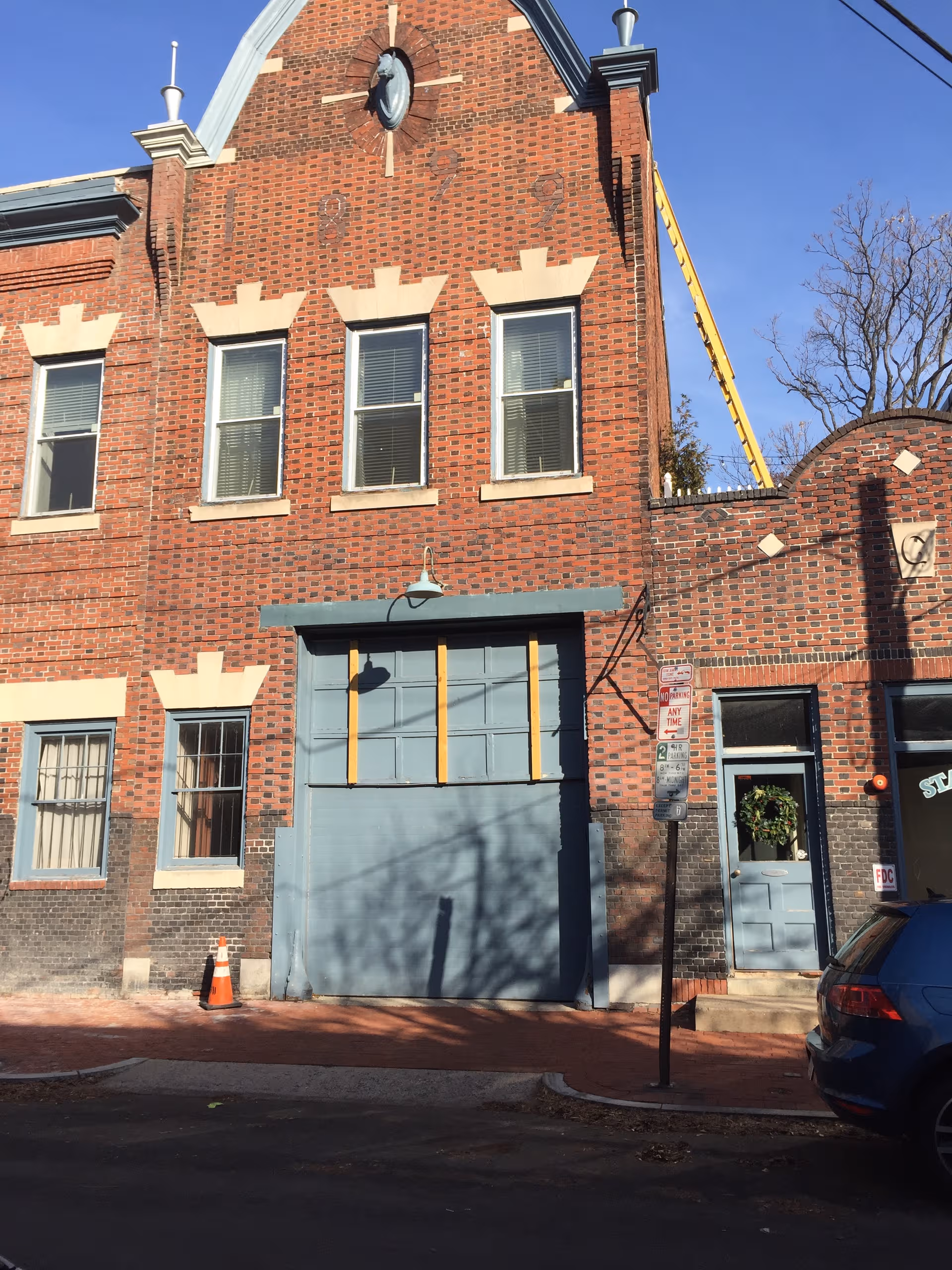 Brick facade of a multi-story building with a large blue garage-style door.