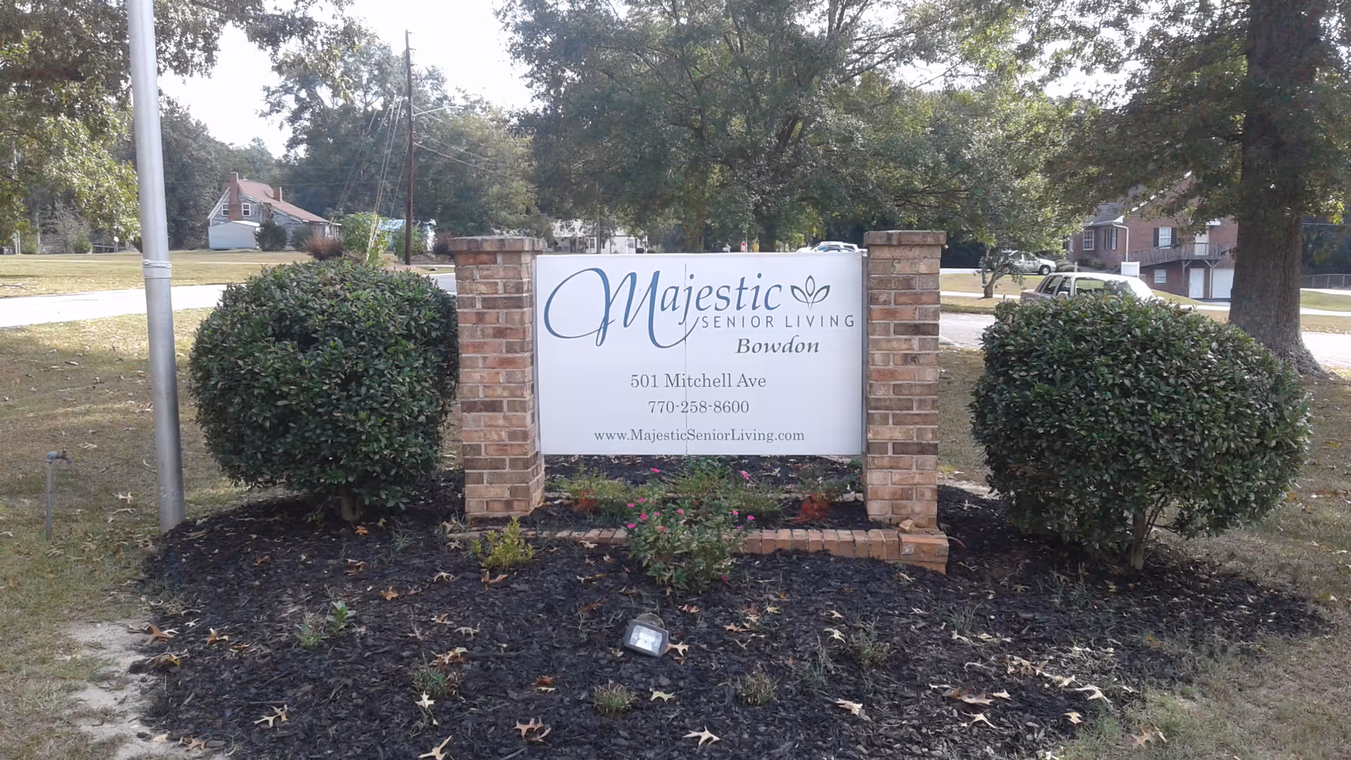 Exterior sign for Majestic Senior Living Bowdon with brick pillars and landscaping.