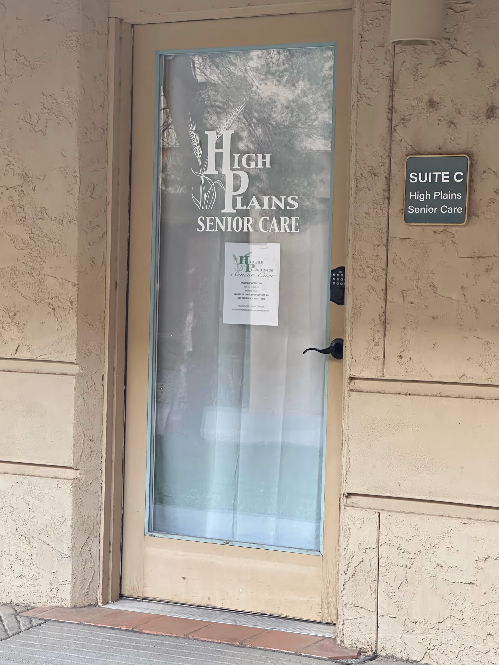 Glass door entrance to High Plains Senior Care with suite plaque on beige exterior wall.