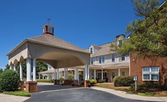 Exterior view of Silvercrest Health and Rehabilitation Center with a covered entrance and driveway, blue sky.