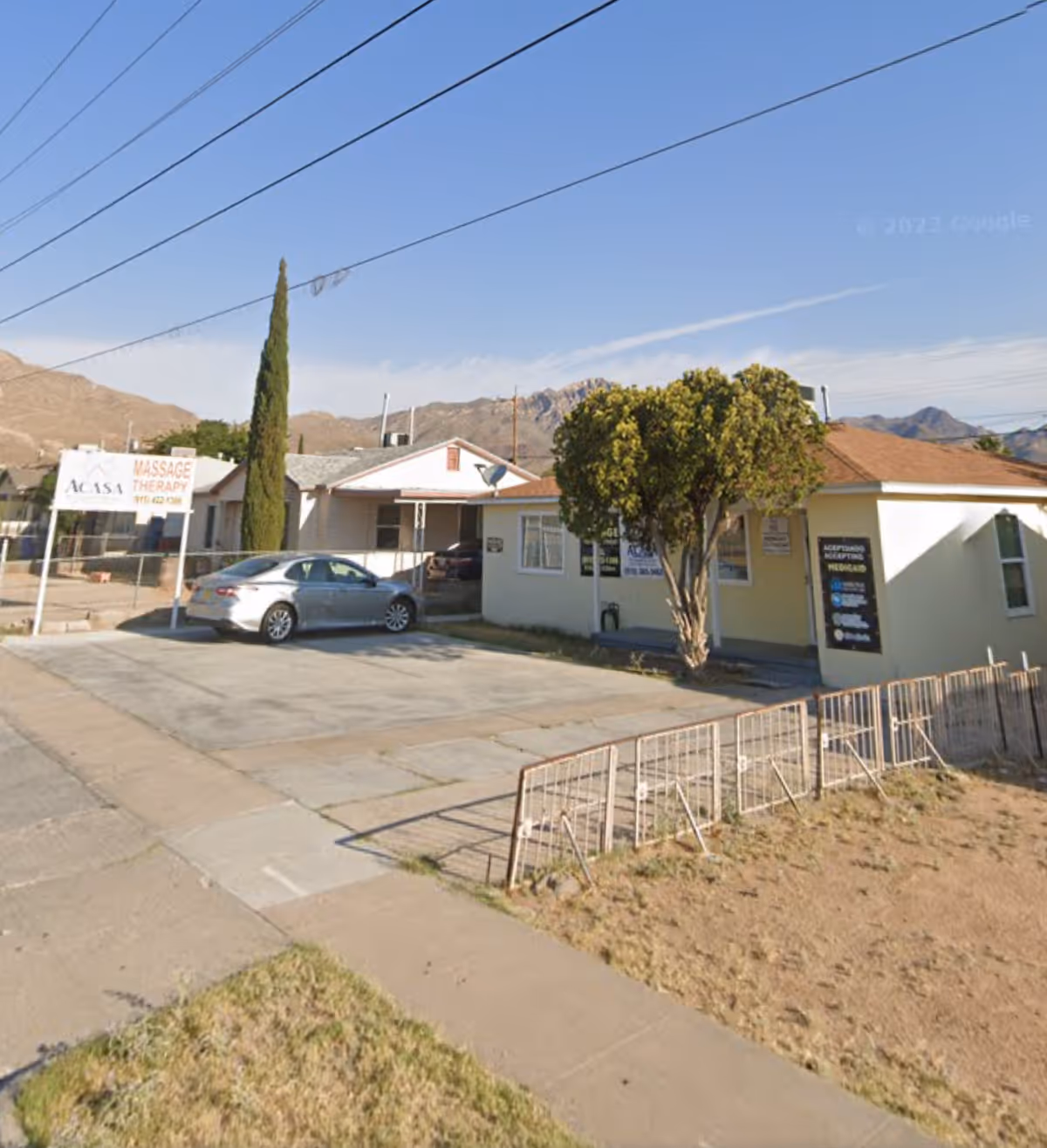 Front view of ACASA Personal In-Home Care facility with parked car and mountains behind.