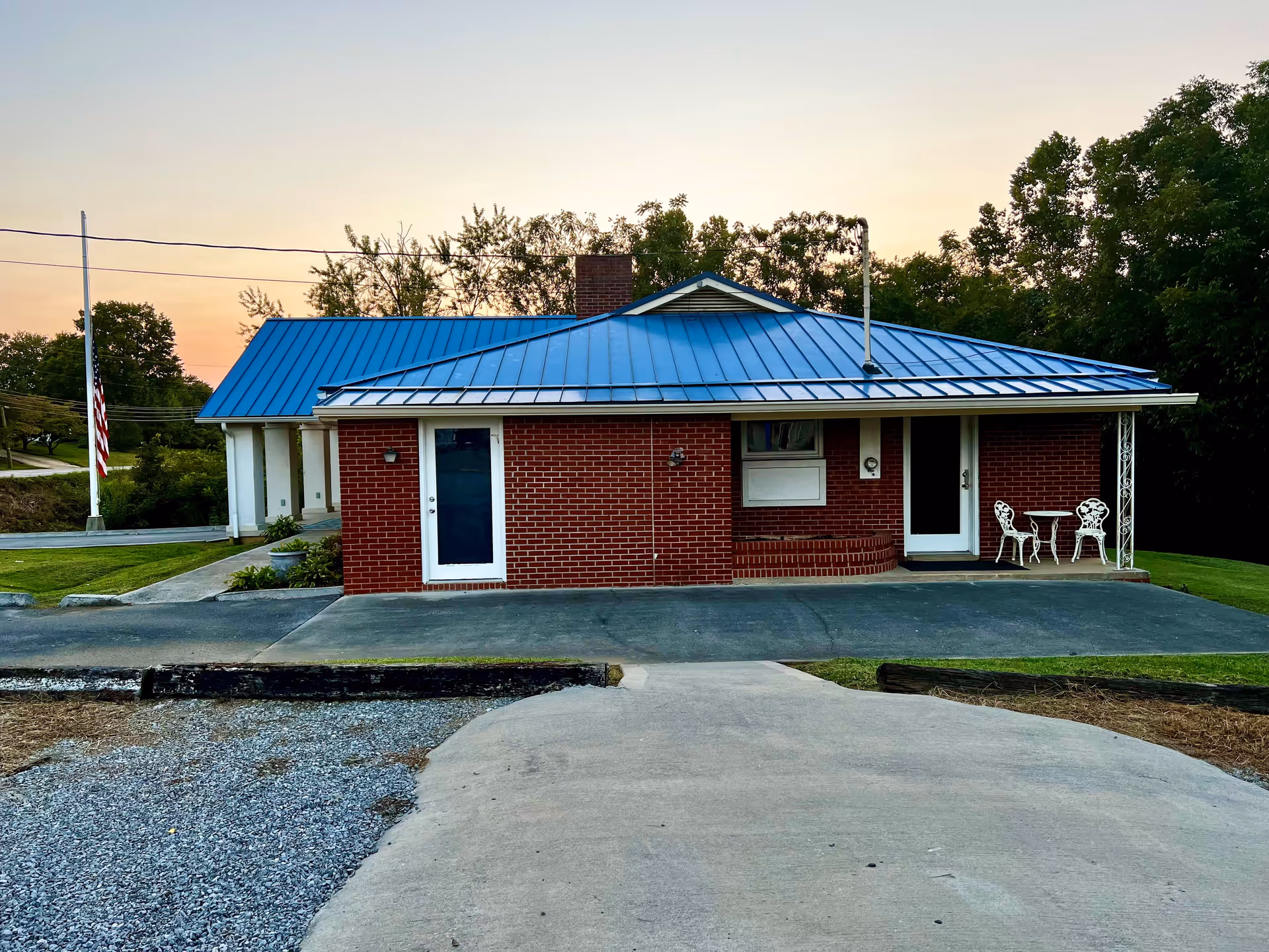 Brick single-story Special Care Incorporated facility with blue metal roof, front entrance, and outdoor seating.