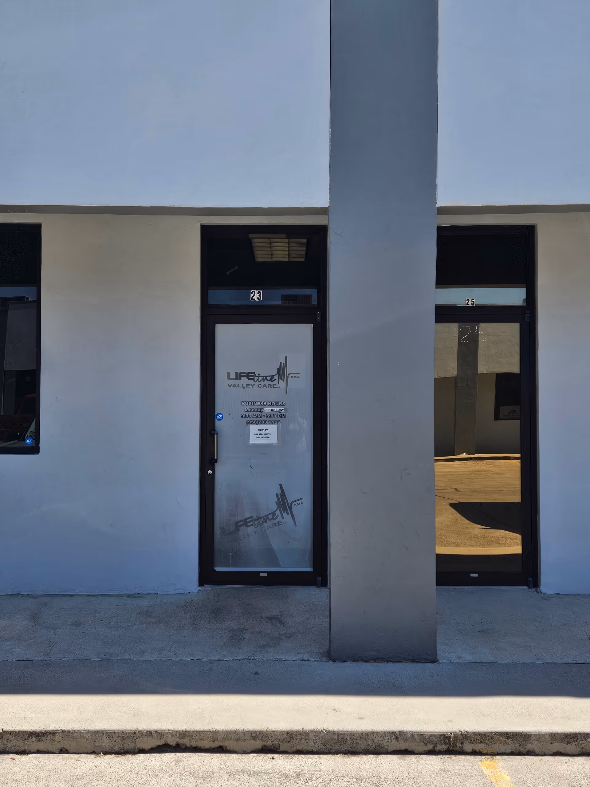 Tall glass doors flank a gray pillar at the building front of Lifeline Valley Care.