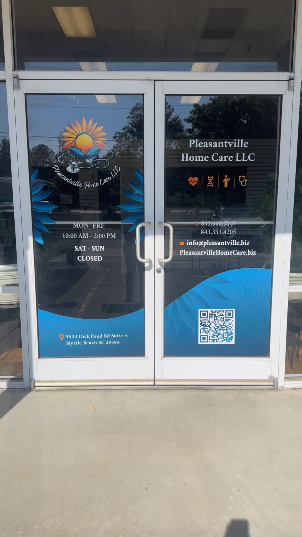 Glass doors display Pleasantville Home Care LLC branding, logo, hours, contact details, and QR code.