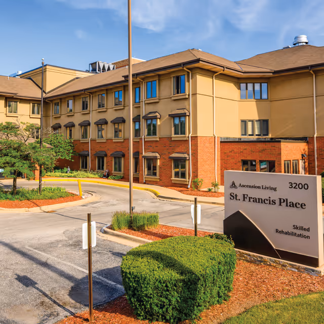 Exterior view of Ascension Living St. Francis Place with landscaped entrance and sign.