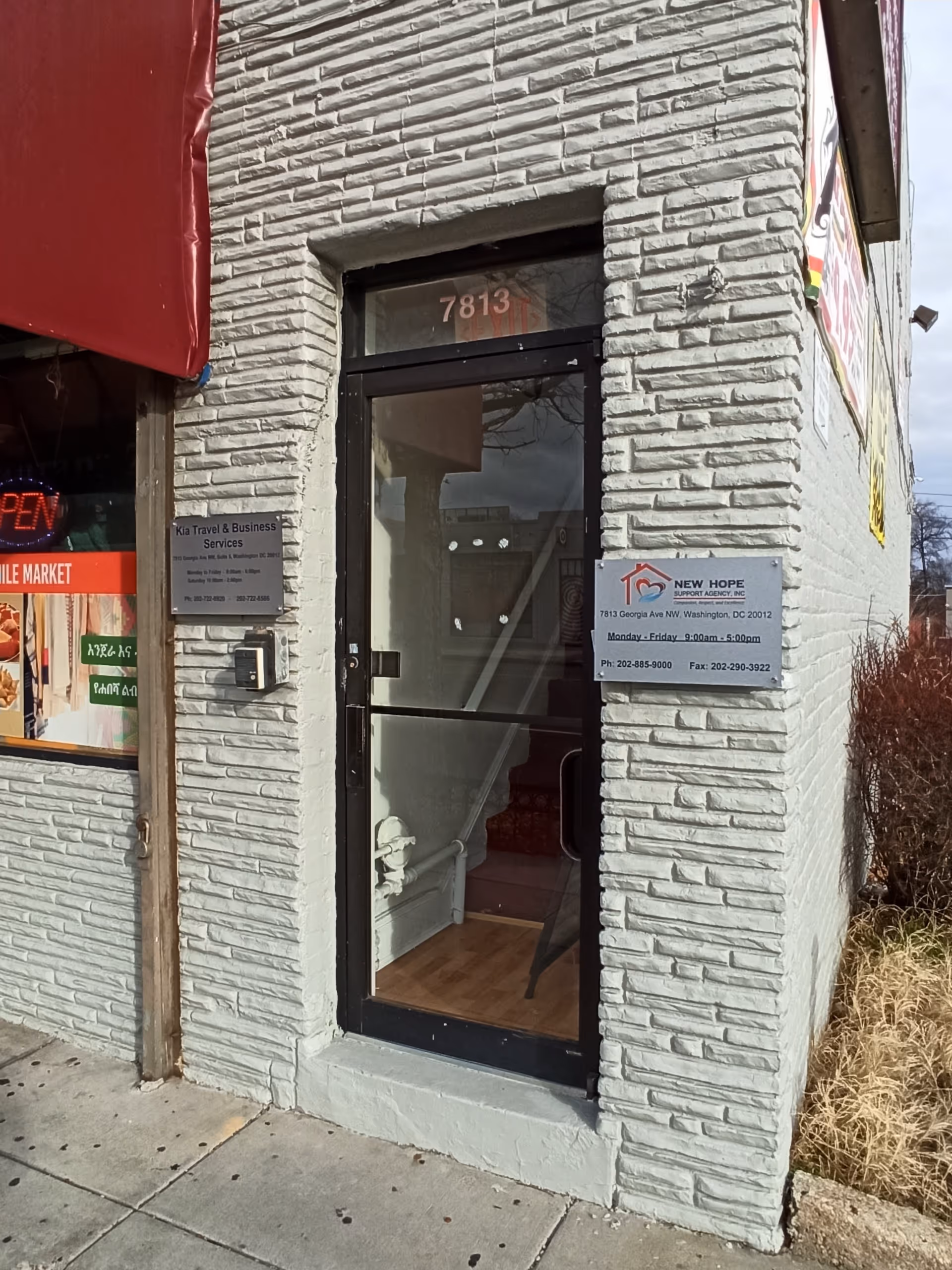 White brick entrance with glass door and New Hope Support Agency, Inc signage
