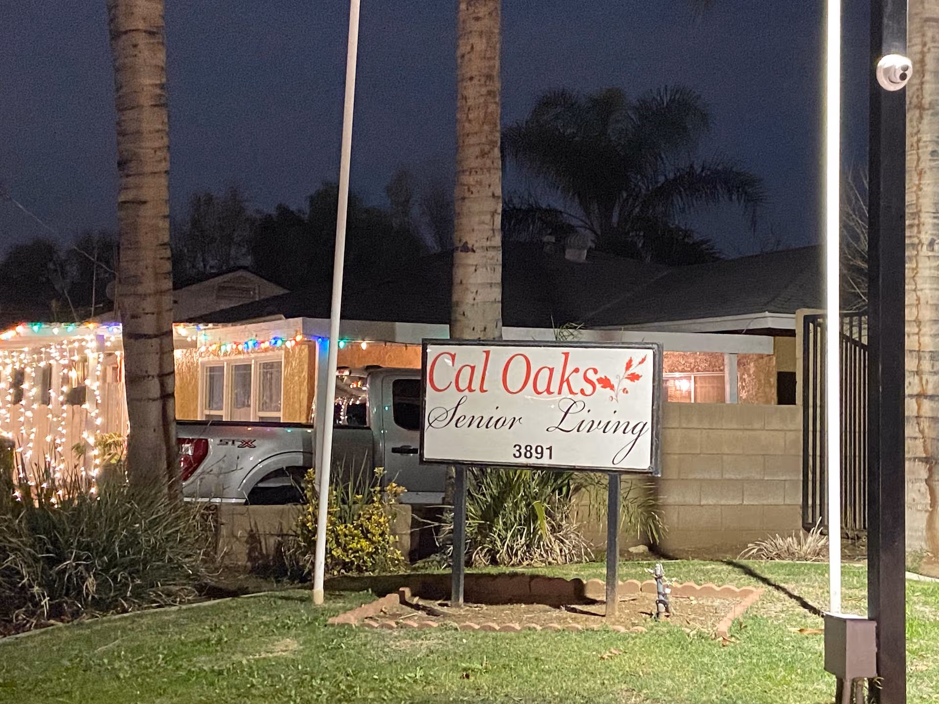 Nighttime exterior view of Cal Oaks Senior Living sign and building front.