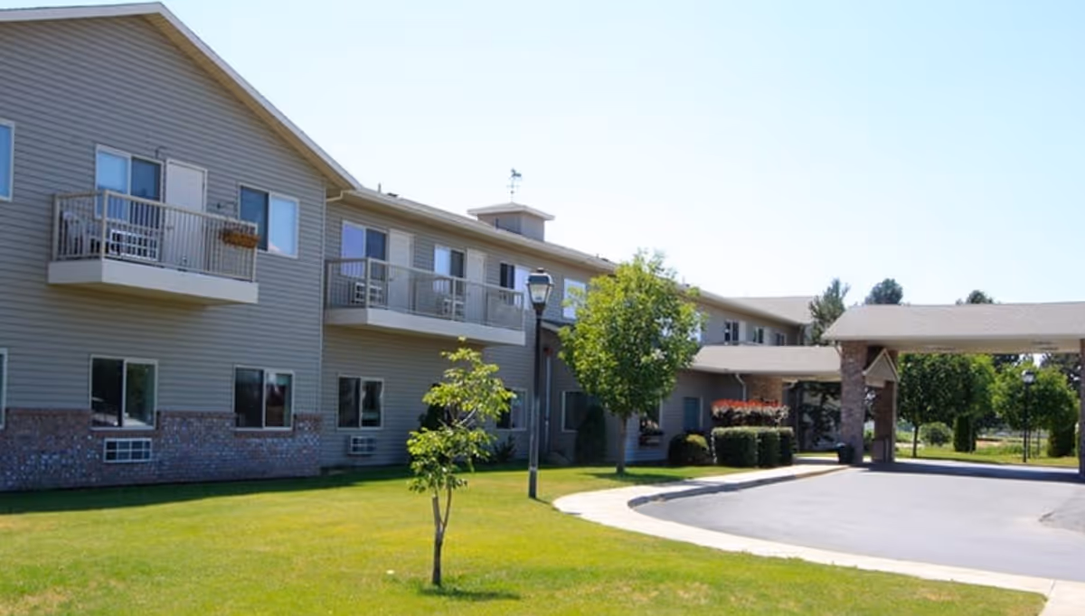 Two-story Sun Terrace Prosser facility with balconies, manicured lawn, and circular driveway.