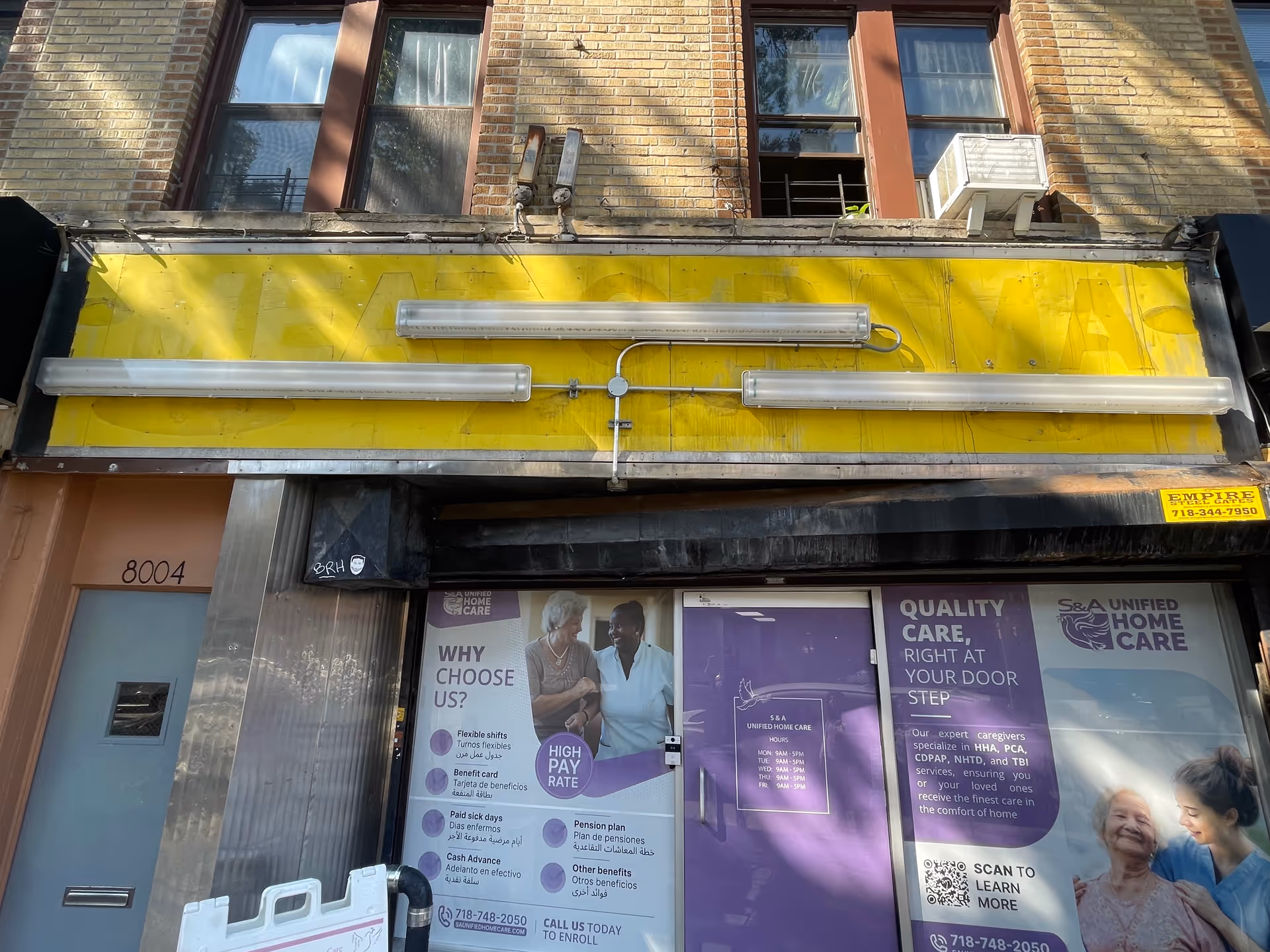 Front of a commercial building housing S & A Unified Home Care with posters.