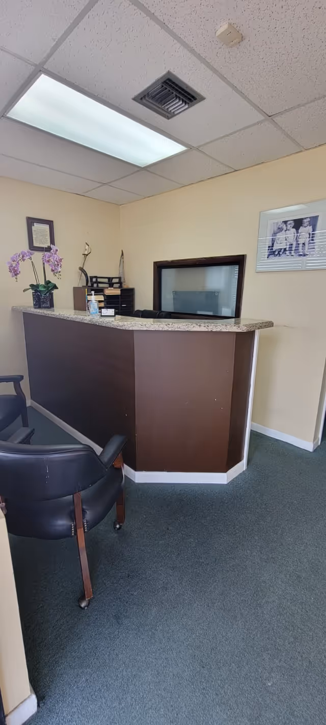 Reception desk with granite countertop in a small lobby at a senior facility.