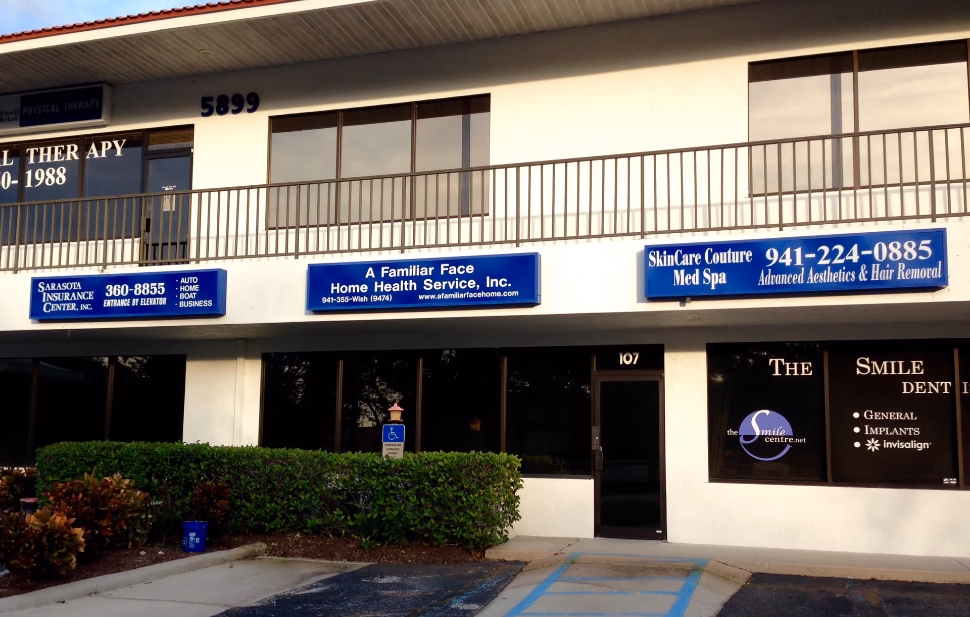 Exterior view of a storefront strip with signs for A Familiar Face Home Health.