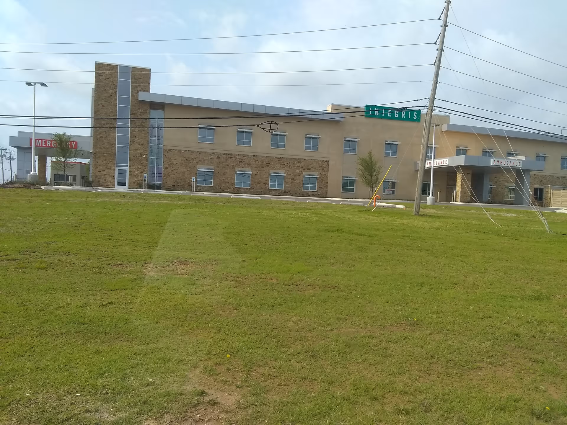 Exterior view of INTEGRIS Health Community Hospital Council Crossing with emergency entrance and lawn.