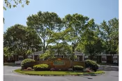 Exterior front view of Queen Anne Nursing Home with trees, landscaping, and a stone sign.